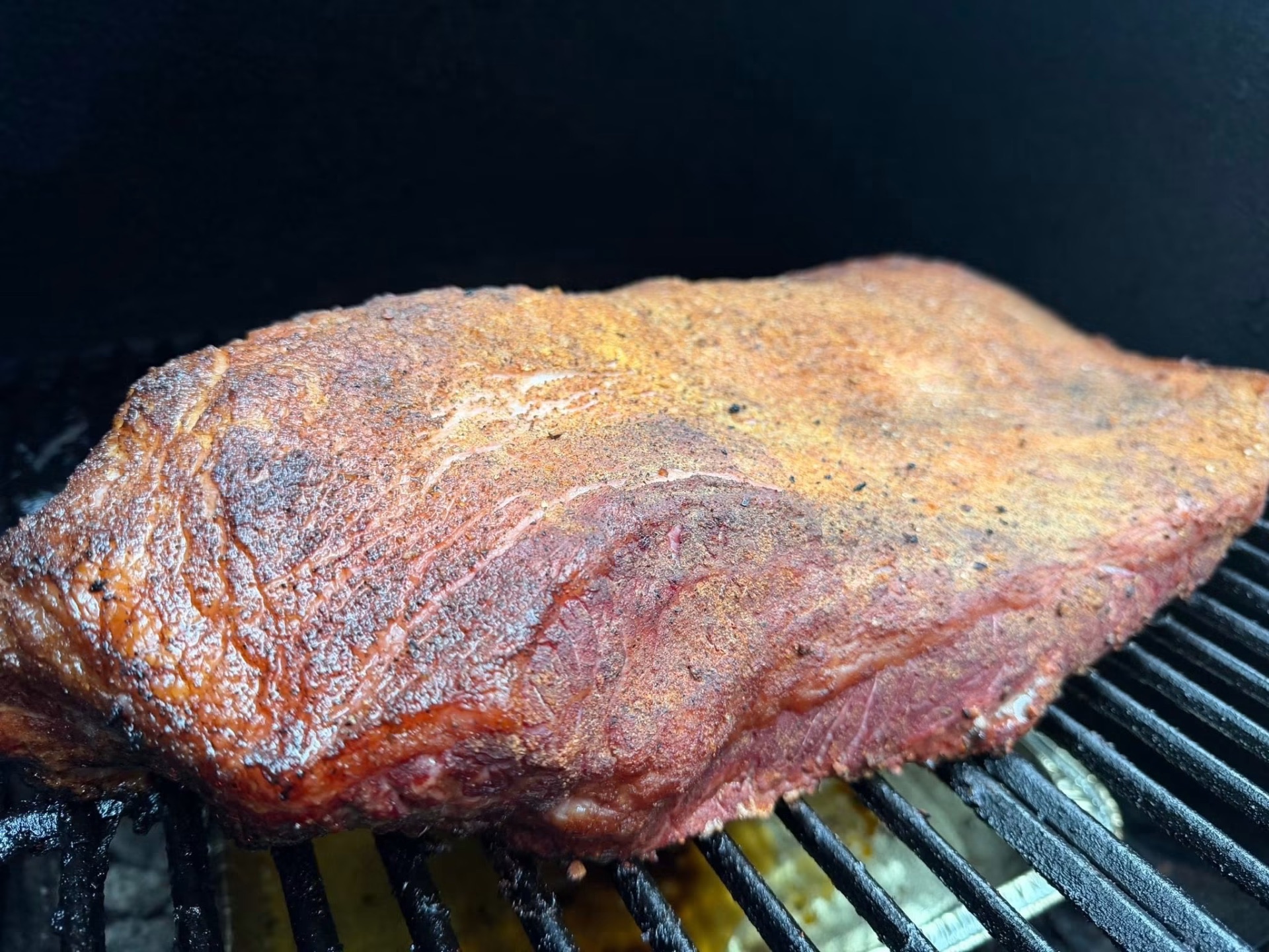 Whole seasoned brisket on Blackened Ridge's smoker grates