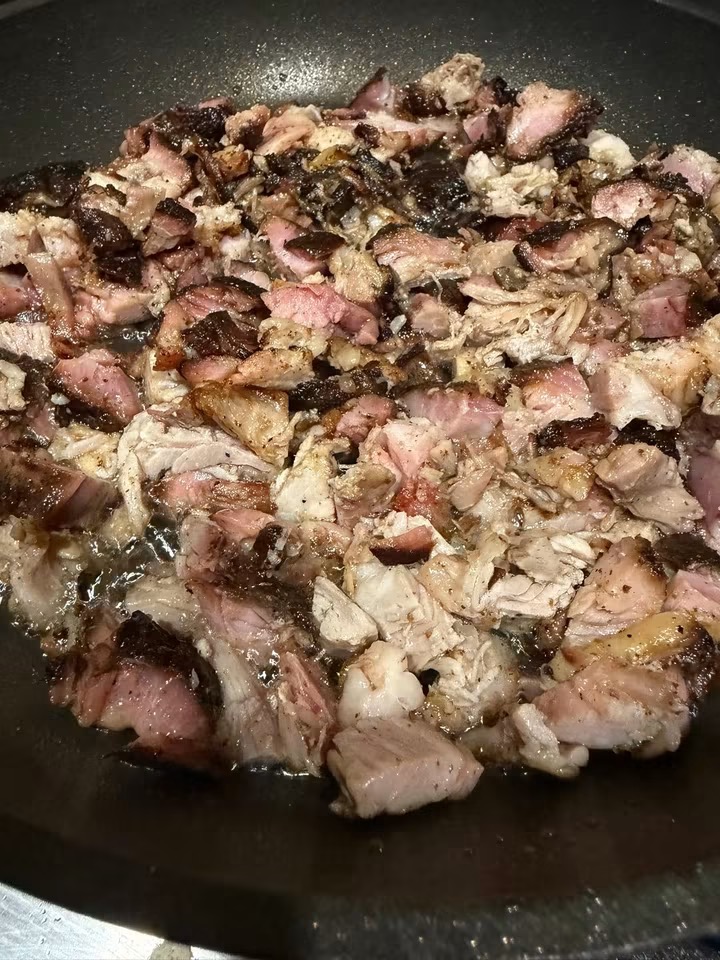 Chopped smoked brisket bark searing in a cast iron pan