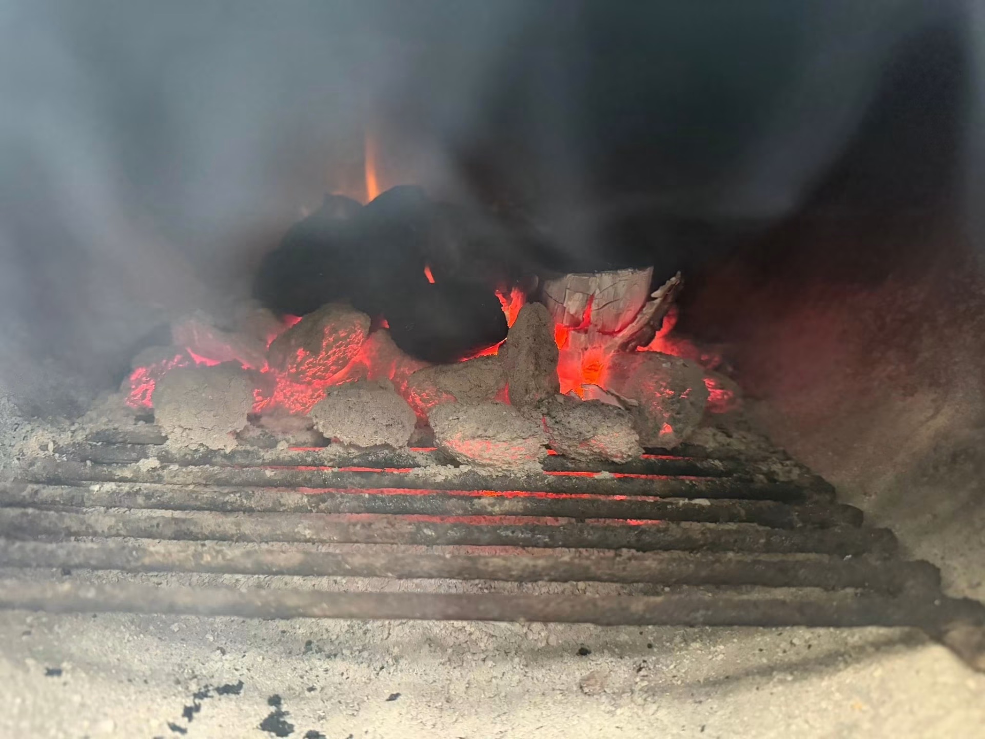 Glowing coals and hickory smoke in our smoker firebox
