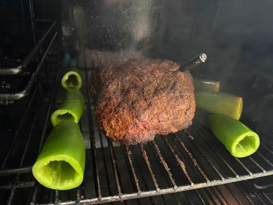 Tri-tip smoking alongside hollowed jalapeños on the grill